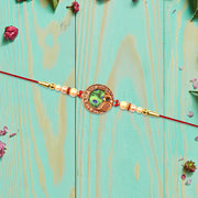 Elegant Rakhi With Peacock Feather Design And Pearl Bead Accents On Red Thread thumbnail 3