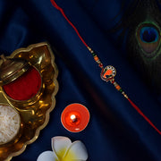 Golden Ganesha Rakhi With Red-green Beads And Stone Detailing thumbnail 3