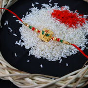 Golden Ganpati Rakhi With Red-green Beads And Enamel Detailing thumbnail 1
