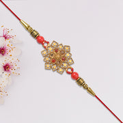 Traditional Golden Floral Rakhi With Intricate Design And Red Beads On Red Thread thumbnail 3