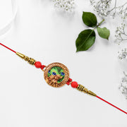 Traditional Krishna Rakhi With Peacock Feather Design And Decorative Beads On Red Thread thumbnail 1