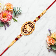Traditional Ganesha Rakhi With Golden Finish And Sacred Red Thread thumbnail 1