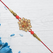 Traditional Golden Floral Rakhi With Intricate Design And Red Beads On Red Thread thumbnail 2