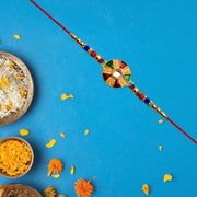 Elegant Multicolor Kundan Rakhi With Golden Floral Round Dial And Beaded Red Thread thumbnail 2
