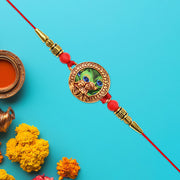 Traditional Krishna Rakhi With Peacock Feather Design And Decorative Beads On Red Thread thumbnail 3