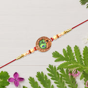 Elegant Rakhi With Peacock Feather Design And Pearl Bead Accents On Red Thread thumbnail 1